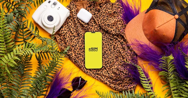 Smartphone affichant « eSIM » posé parmi des affaires de voyage