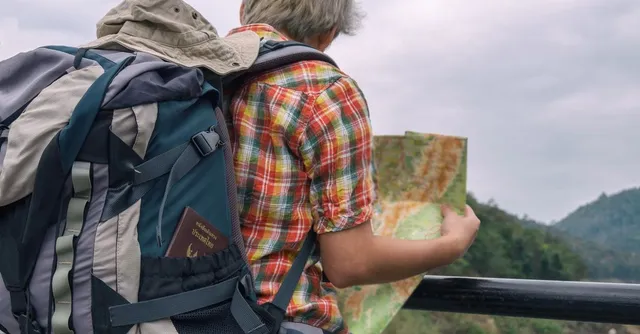 Voyage en solo : sac à dos, passeport et carte face à des collines